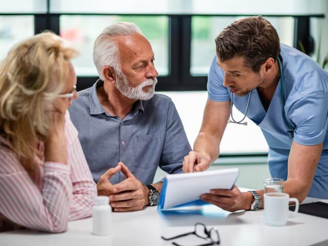 A doctor discussing medical documents with a senior couple